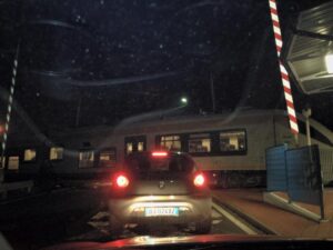 Foto choc: treno in transito a Villanova con le sbarre del passaggio a livello alzate